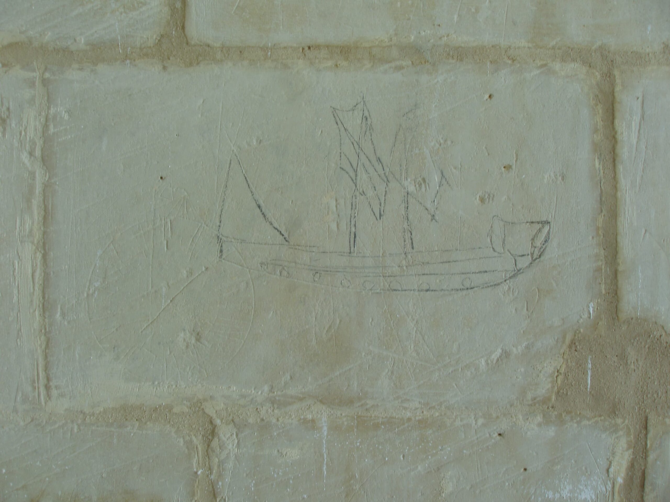 This ship graffito is drawn on the wall with a dark-coloured implement, not etched. The ship’s hull is visible complete with two masts and a mizzen. The typology is difficult to discern.