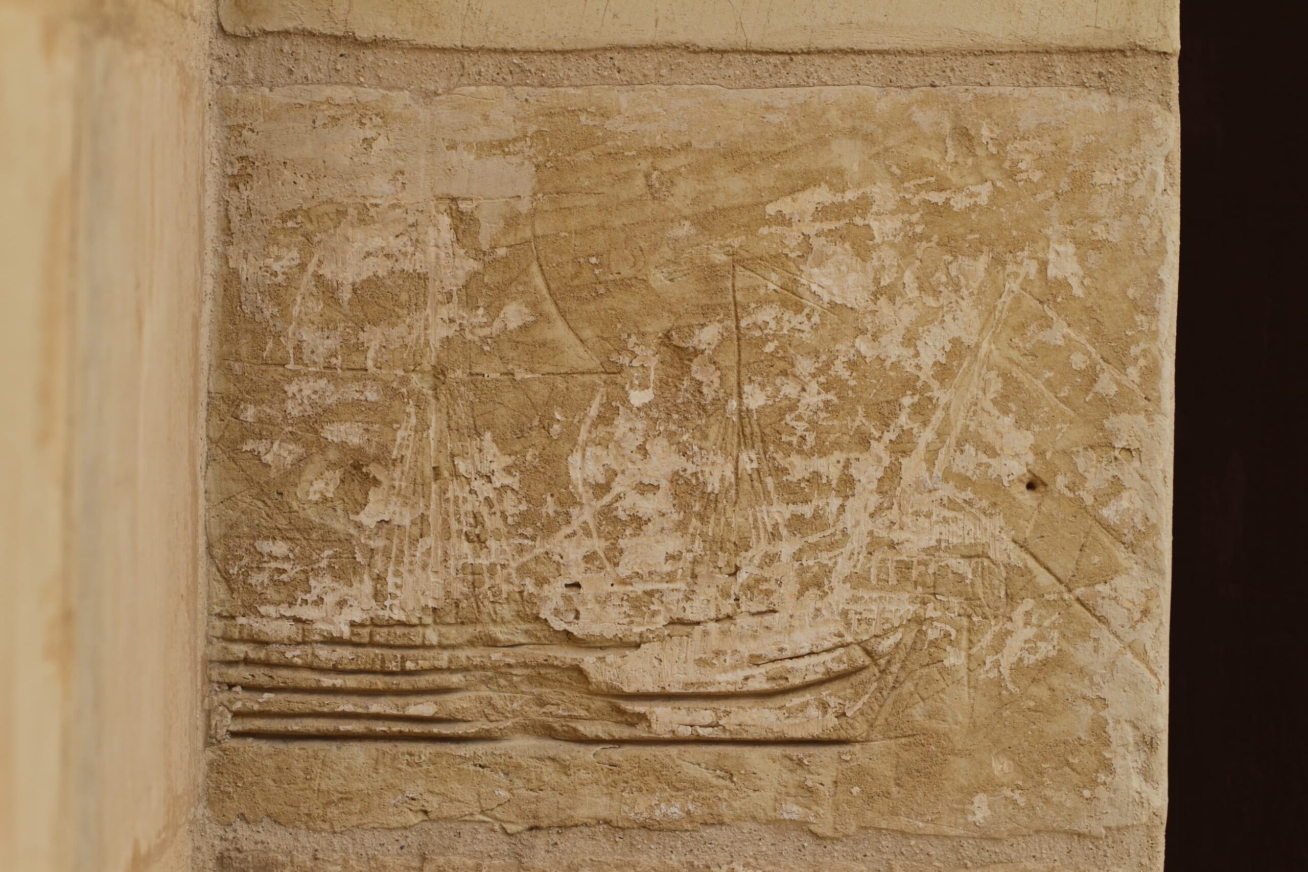 A deeply incised ship graffito bearing evidence of square rigging and flags. The typology of the ship is difficult to discern.